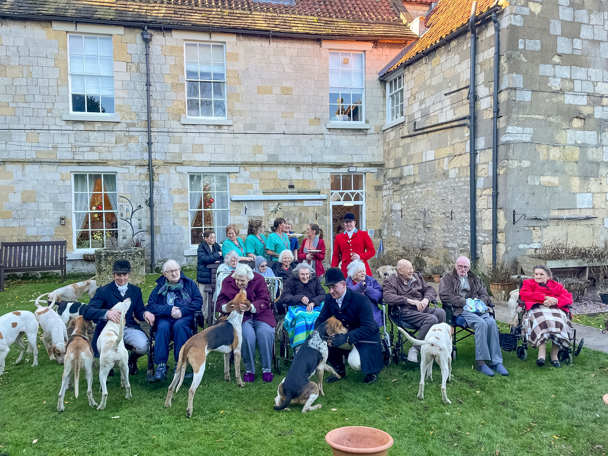 Staff and residents of The Abbey residential home in Old Malton, North Yorkshire, enjoying a visit from the hounds and huntsmen of the Middleton Hunt, in a tradition dating back over 30 years. Image: BHSA